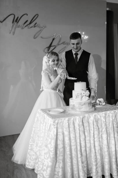 istock Bride and groom cutting and tasting wedding cake 1894385356