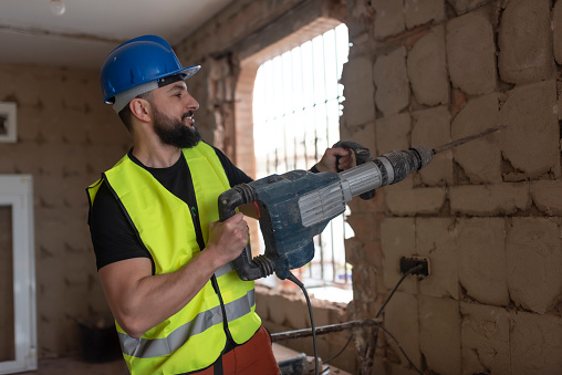 construction worker picks the wall to put tiles