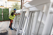 construction worker prepares the aluminum window frames to be placed on the construction site