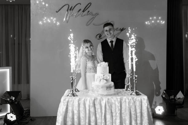 istock Bride and groom cutting and tasting wedding cake 1894415519