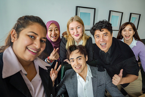 happy business team taking selfie in boardroom after business meeting