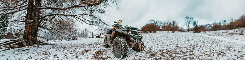 A young adventurous couple embraces the joy of love and thrill as they ride an ATV Quad through the snowy mountainous terrain.