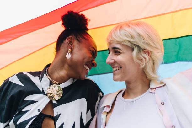 istock Lesbian couple face to face with rainbow flag on background 1894537619