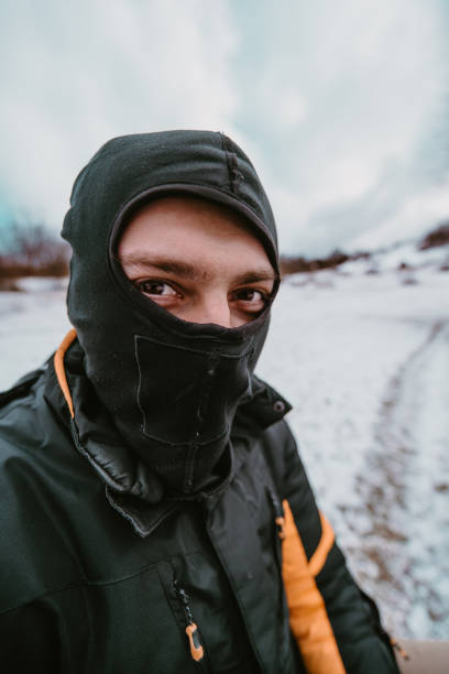 In this dynamically captured wide-angle photograph, a rugged man in a balaclava is seen up close, gearing up for an extreme quad ride through the snow, showcasing anticipation and readiness for an adrenaline-fueled adventure in the frost-covered terrain. en esta fotografía de gran angular capturada dinámicamente, se ve de cerca a un hombre robusto con pasamontañas, preparándose para un paseo extremo en quad por la nieve, mostrando anticipación y preparación para una aventura llena de adrenalina en el