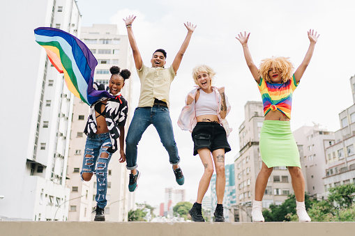 Portrait of a lgbtqia+ friends jumping outdoors