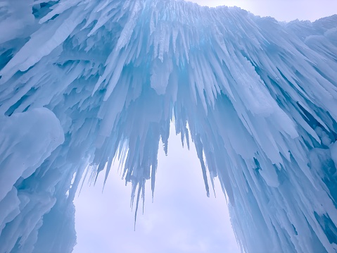Large frozen icicles hanging to make beautiful sculpture scenery winter photo. View from below