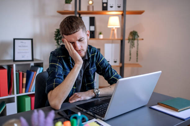 istock Young man working home office and cannot believe what he has seen on laptop 1894686740