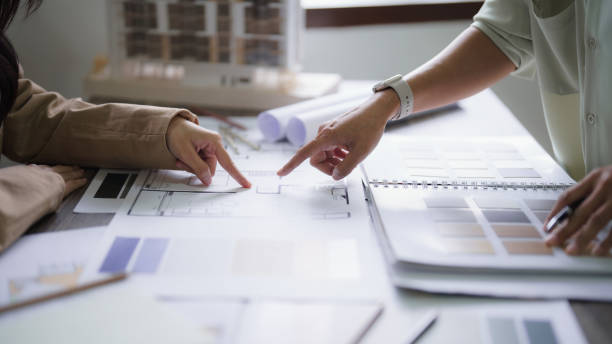 istock Two female architect discussion and inspection interior designing and building project on blueprint 1894752338
