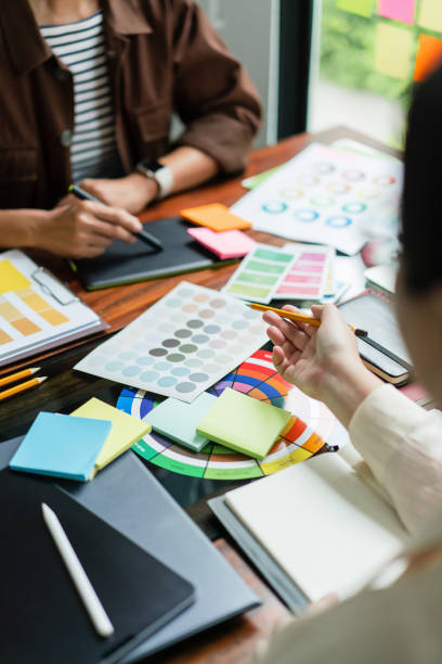 istock Two creative graphic designers discuss about color swatch to designing project and sketch on tablet 1894752357