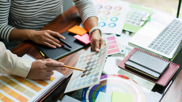 istock Two creative graphic designers discuss about colors swatch to designing project and draw on tablet 1894752953