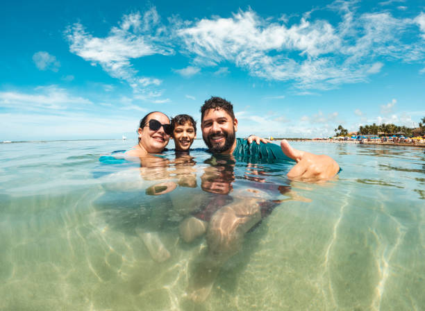 istock Family on the beach looking at camera 1894765904