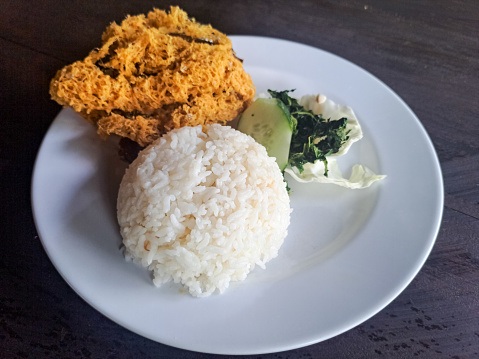 Delicious Ayam Goreng Kremes Or Crispy Fried Chicken With Crispy Spiced Flakes, Rice, Cucumber Sliced, Cabbage And Boiled Cassava Leaves. Food Menu.