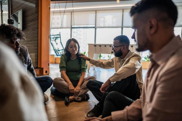 istock Businessman consoling coworker during group therapy on the office 1894774354