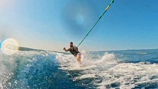 Happy boy - young surfer with bodyboard have fun on beach, run by sea water pool. Active family lifestyle, kids outdoor water sports, swimming activity in surf camp. Summer vacation with child.