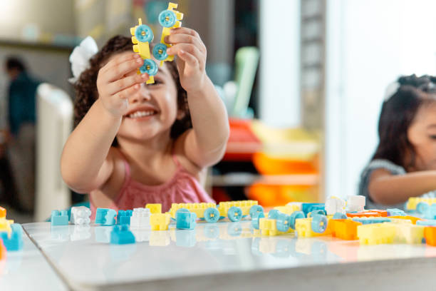 retrato de un niño pequeño latinoamericano jugando con un bloque de colores - preschooler child playing latin american and hispanic ethnicity fotografías e imágenes de stock