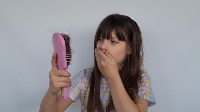 Frightened and shocked caucasian girl with long hair on comb