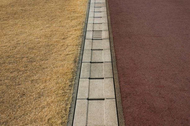 istock Rainwater gutter that separates the ground and lawn in a winter park 1894841311