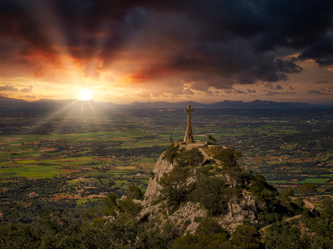 Christ cross by Sunset on the mountain Puig de Sant Salvador near by the town of Felanitx - Majorca / Spain