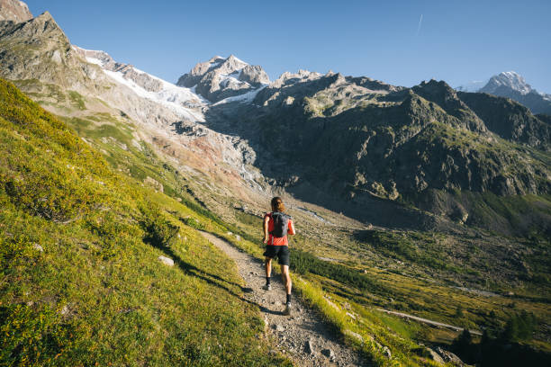 Trail runner bounds along mountain trail