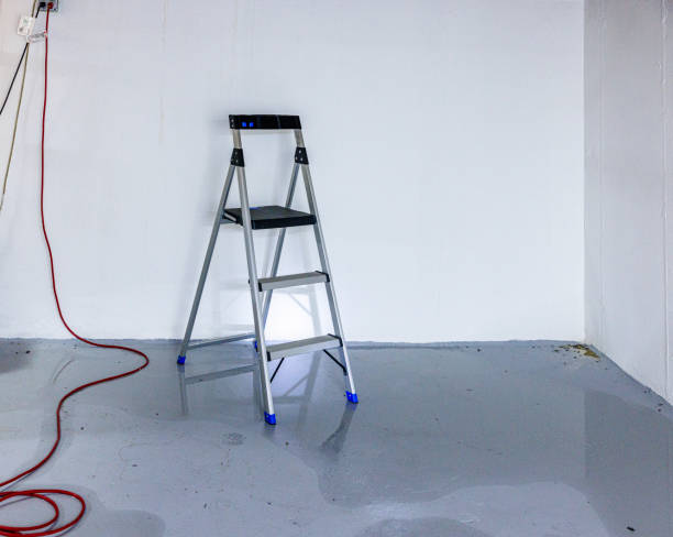 Groundwater flood in basement. Stepladder and de-energized wires in the flooded basement Groundwater causing basement flooding: stepladder and wires lie on the wet floor basement floor drain stock pictures, royalty-free photos & images