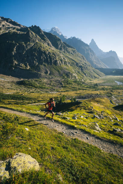 istock Trail runner bounds along mountain trail 1894927813