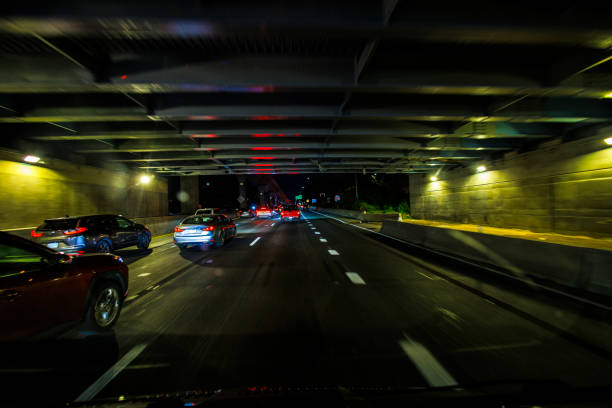 Nighttime driving to JFK airport in Queens. Van Wyck Expressway passes under the monorail bridge. POV of car