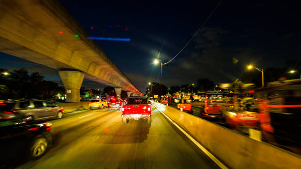 istock Construction works along with the Van Wyck Expy at night Queens. Red lights illuminate the monorail overpass above the highway. POV of car 1894945306