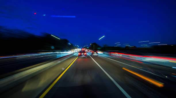 Car light trails illuminate the road in night city. Long exposure, POV of driver Night city driving in Brooklyn, New York. Light trails illuminate the highway. Driving plate car city urban scene commuter stock pictures, royalty-free photos & images
