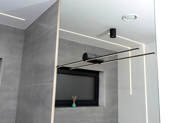istock LED light strips mounted in the wall and ceiling in a modern bathroom, visible black wall lamp. 1895012252