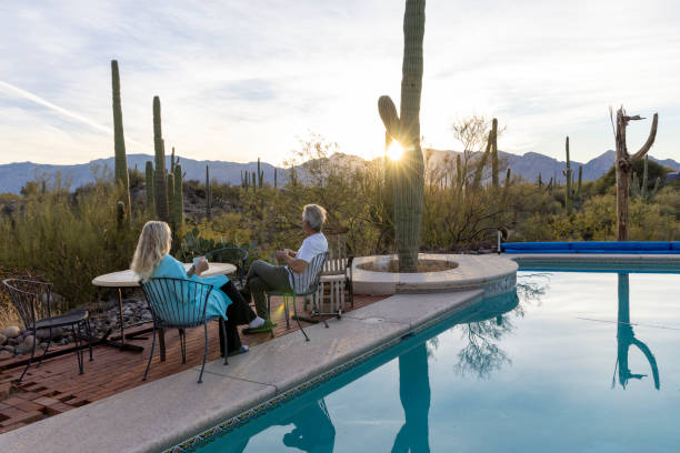 Mature couple relax by pool at sunrise