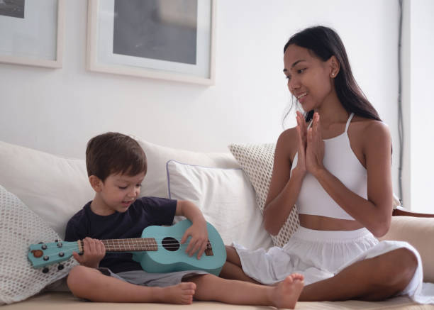 istock Proud Mother Supporting Her Son Playing Guitar 1895073096