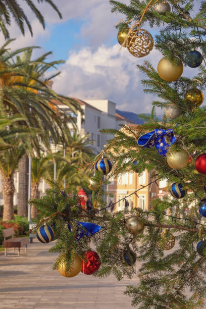 istock Bright Christmas balls on decorated Christmas tree on sunny day. Winter Mediterranean landscape. Montenegro, Tivat city 1895084006