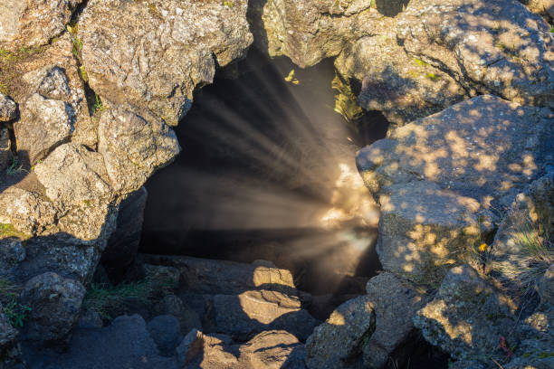 Sun rays reflected from water surface at entry into Grjótagjá cave in Iceland Sun rays reflected from water surface at entry into Grjótagjá cave in Iceland. Cave close to Mývatn lake grjótagjá thermal spring stock pictures, royalty-free photos & images
