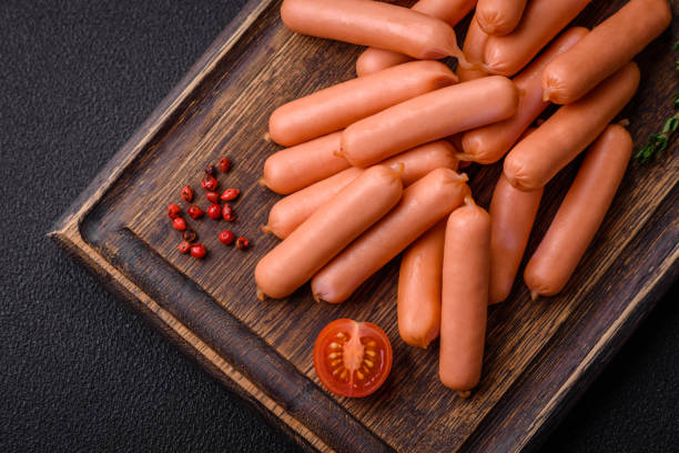 istock Delicious small sausages with salt, spices and herbs 1895183790