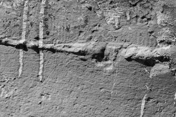 istock Light grey concrete wall with deep scratches and chips. Various variations of abrasions. 1895204879