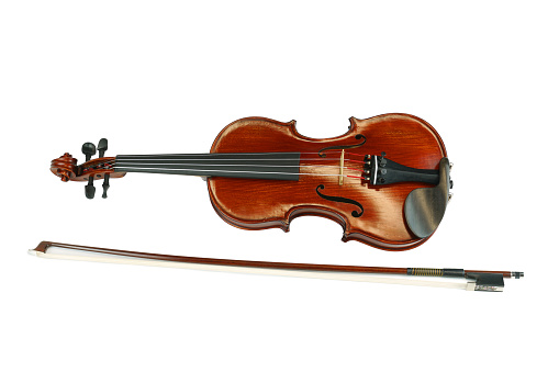 Overhead view of a wooden violin on sheet music. 