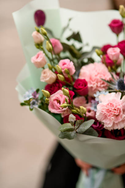 istock Close up view of flower bouquet with eustoma, carnations, anthurium and eucalyptus wrapped in mint color paper 1895244792
