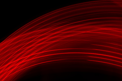 Fiber optic light effect in red color on dark background. Abstract image reflecting futuristic and cutting-edge technology.