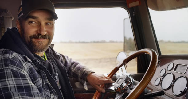 istock Happy mature farmer wearing a cap driving a tractor 1895291944