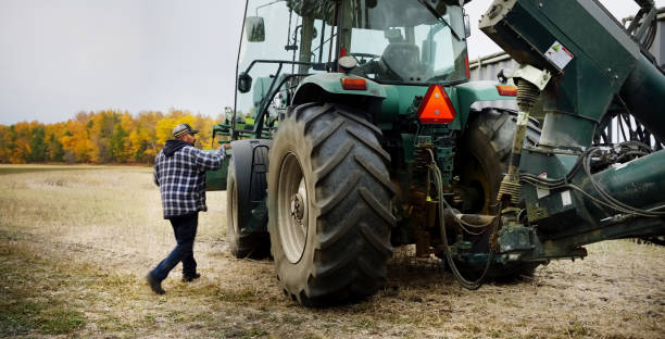 Man walking toward a tractor auger while working outside on his farm