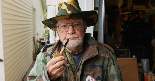 istock Elderly Man Wearing Camouflage Jacket with a Smoke Pipe 1895355441