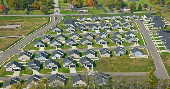 Aerial still of tract housing in Georgetown, a city in Scott County, Kentucky, on a mostly clear day in Fall.