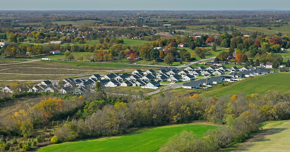 Aerial still of tract housing in Georgetown, a city in Scott County, Kentucky, on a mostly clear day in Fall.