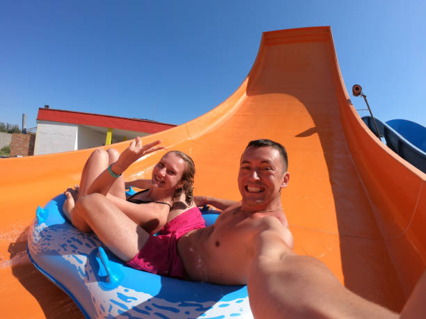 istock Happy couple having fun in water slides. Amusement, aqua. 1895464904
