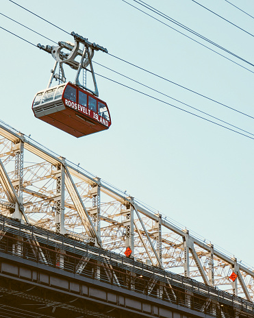 High above, a tram glides serenely, a quiet vantage point over the bustling island below.