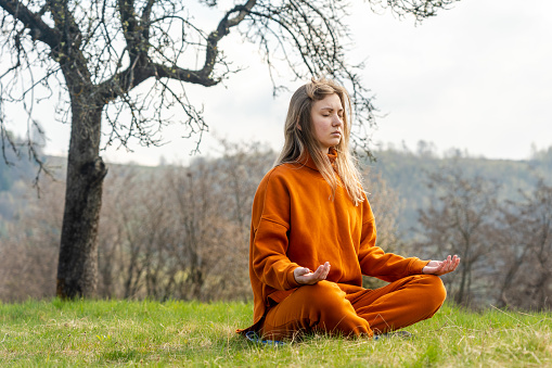 Young woman meditating yoga on the mountain. Relax and calm