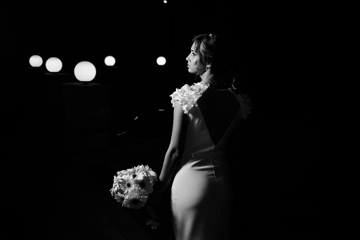 Cropped shot of an unrecognizable bride standing alone outside and holding her bouquet on her wedding day
