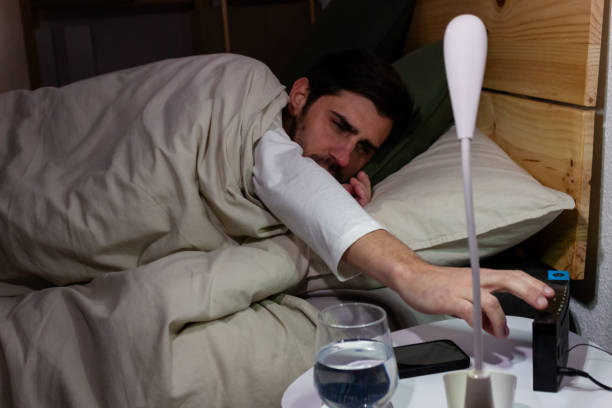 istock sick man lying in bed at night suffering from fever and headache 1895649501
