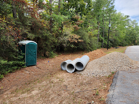 Vacant lot building site.  Outhouse and culvert pipes next to the road.  Ready for the county to install the culvert so construction may begin.