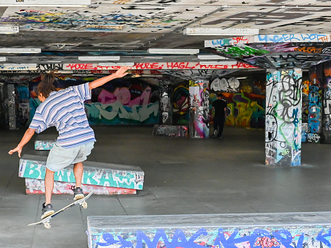 London, UK, 15 August 2023: Young British skateboarder skating at London Southbank Skate Space, an urban culture landmark used by skateboarders